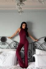 Femme portant une combinaison halter bordeaux élégante et moderne.